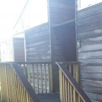 Image of a building showing cedar cladding looking very dark and unkept.